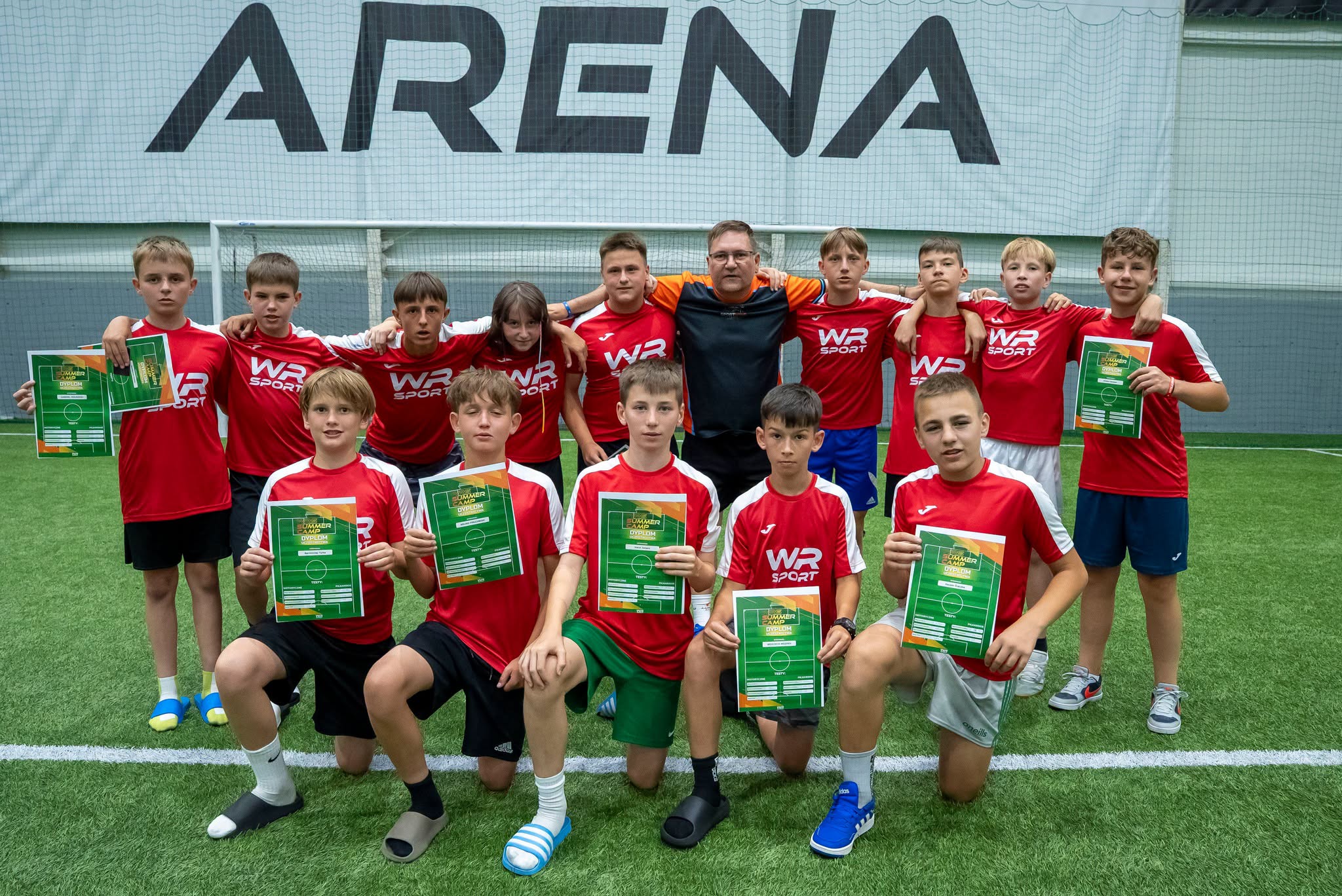 Drużyna z dyplomami na tle banera WRS Arena