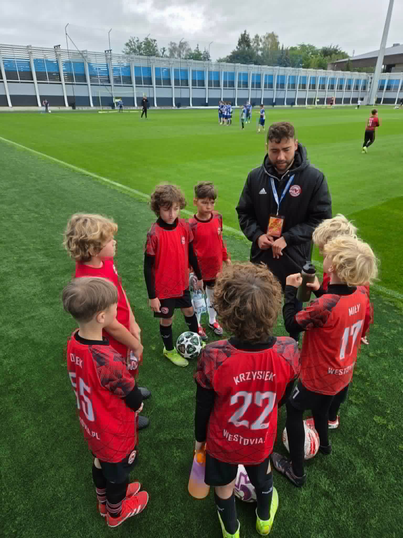 Trener SportMind Team Tarnów z młodymi zawodnikami Westovii na boisku